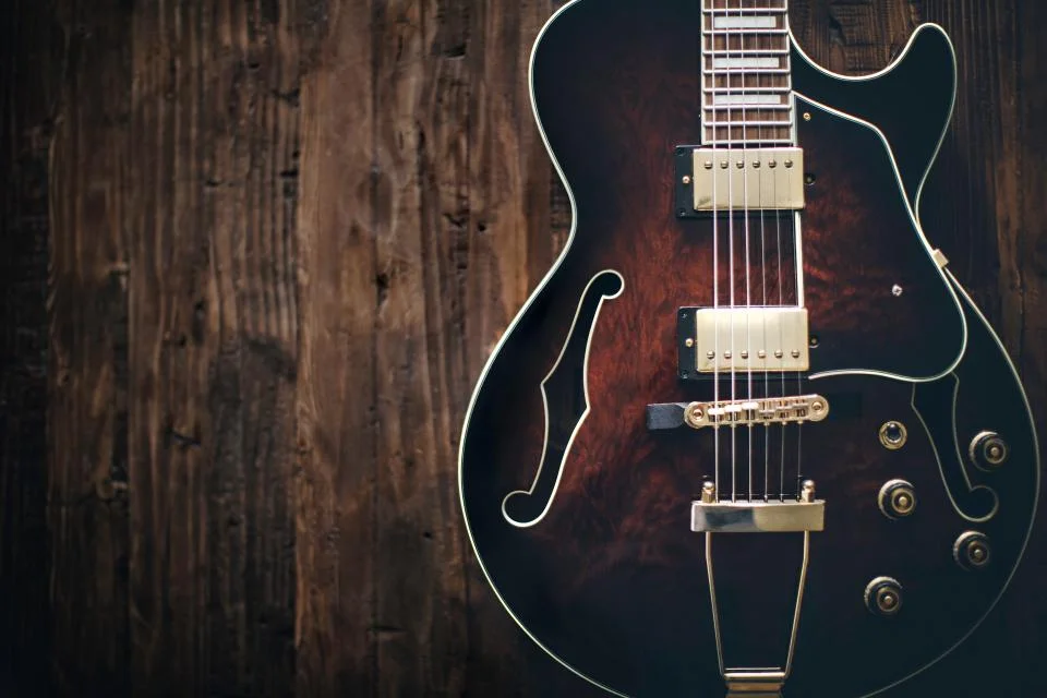 Semi-hollow electric guitar on a wooden wall